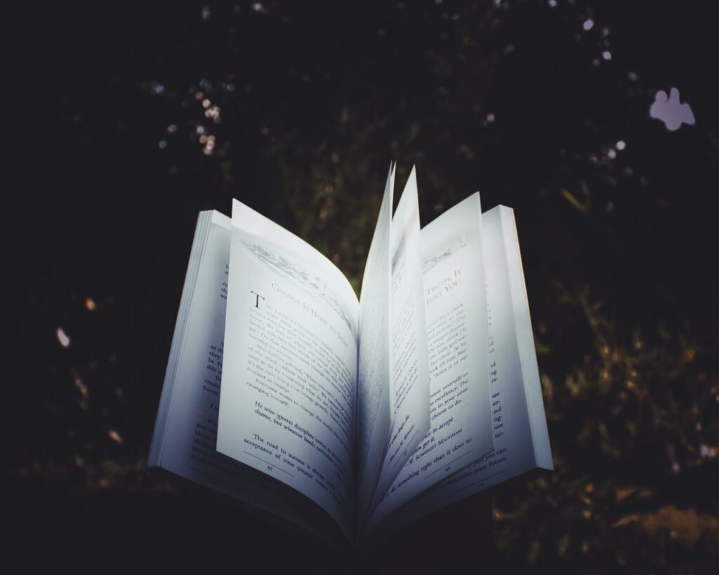 An open book with pages turning, captured outdoors, creating a dreamy reading atmosphere.